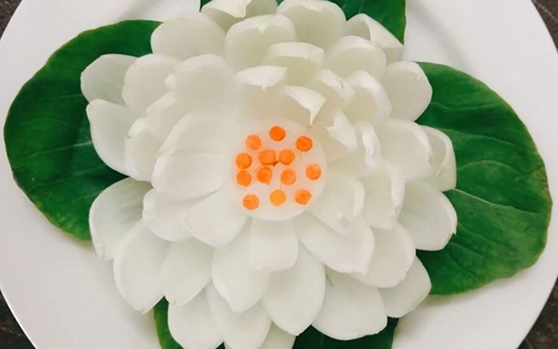 Carving white lotus flowers from onions