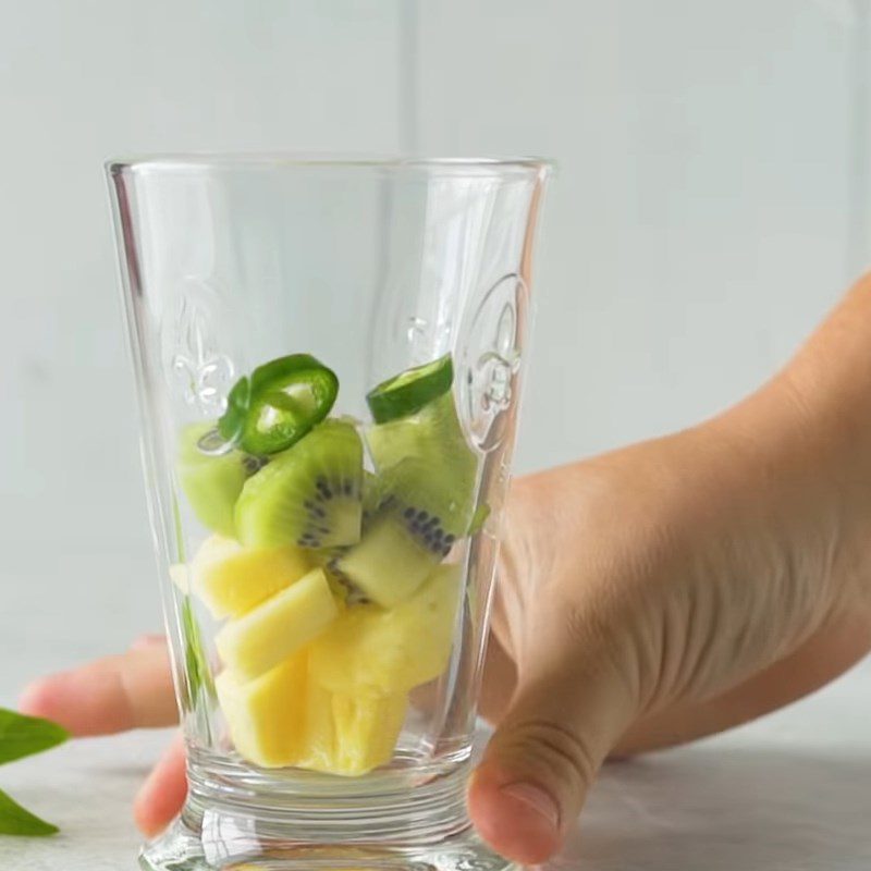 Step 1 Prepare and muddle the fruits for Kiwi Pineapple Gin Tonic