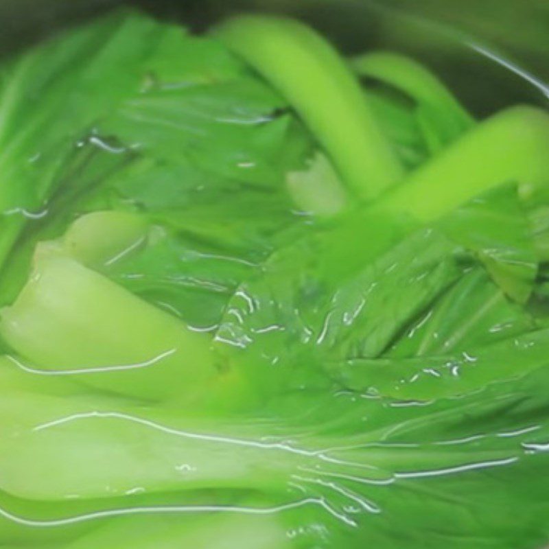 Step 5 Boil the greens and carrots of the steamed red tilapia