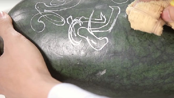 Using a cloth to wipe off the ink stains after carving