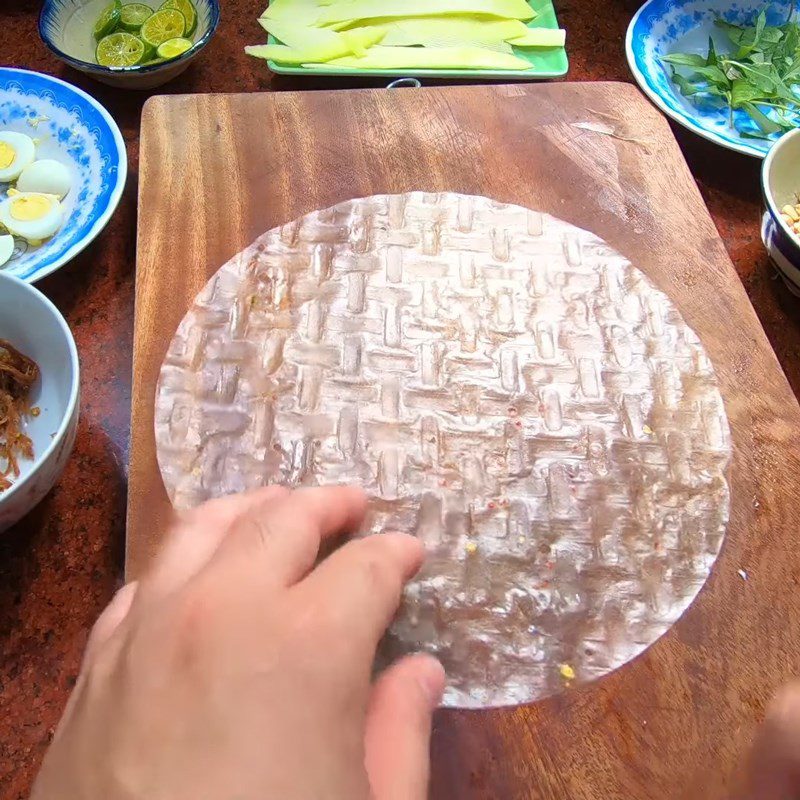 Step 5 Rolling rice paper for red rice paper rolls with quail eggs