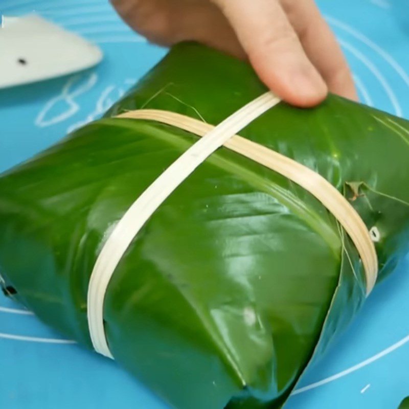 Step 4 Wrapping the square cake with black sticky rice and pork filling