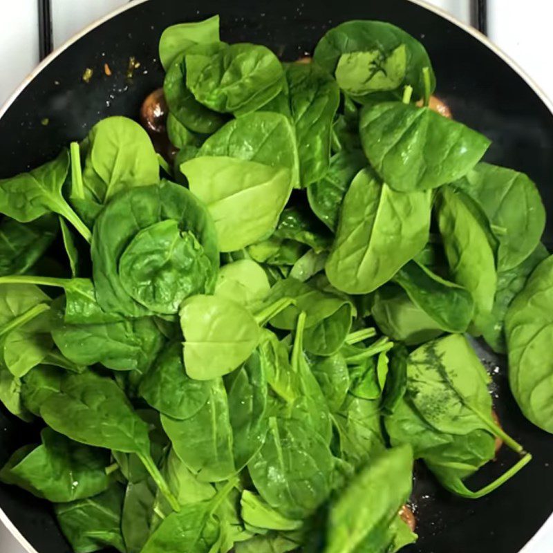 Step 2 Stir-fry the ingredients for Stir-fried Spinach with Garlic and Mushrooms