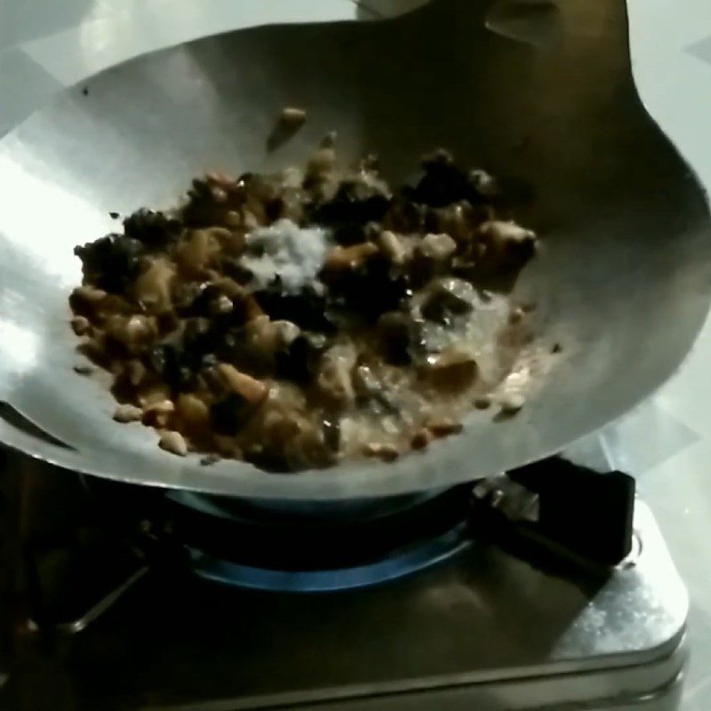 Step 2 Sauté the snails and straw mushrooms for Snail Porridge