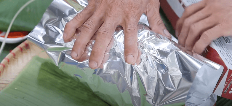 Step 4 Wrapping chicken with clay for baking in foil