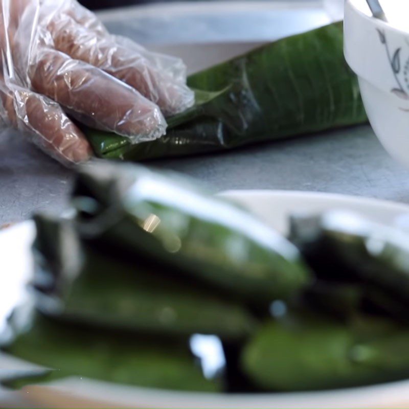 Step 4 Wrapping grilled snail cake in banana leaves